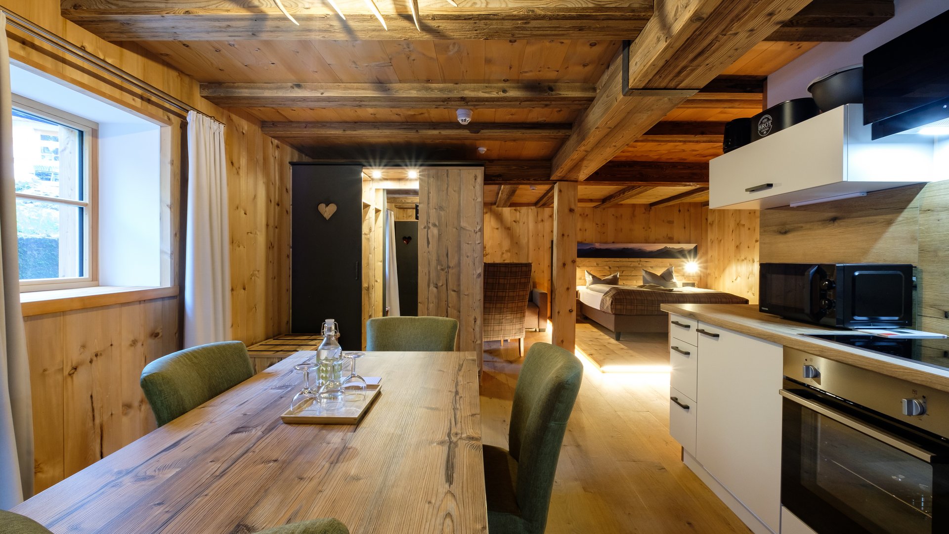 Mit einem Lächeln aufstehen im Hotel am Spitzingsee Gemütliche Holzferienwohnung mit Essbereich, Küche und Schlafzimmer