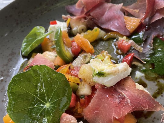 The perfect menu for your event Colorful appetizer with ham, vegetables, leafy greens, and cheese on gray plate