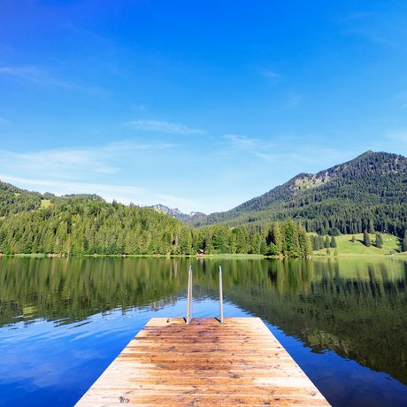 A look at Alte Wurzhütte Dock on a calm lake with mountain view and clear blue sky