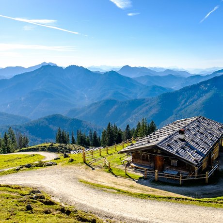 A look at Alte Wurzhütte Alpine cabin with mountain view and winding hiking trail under clear sky