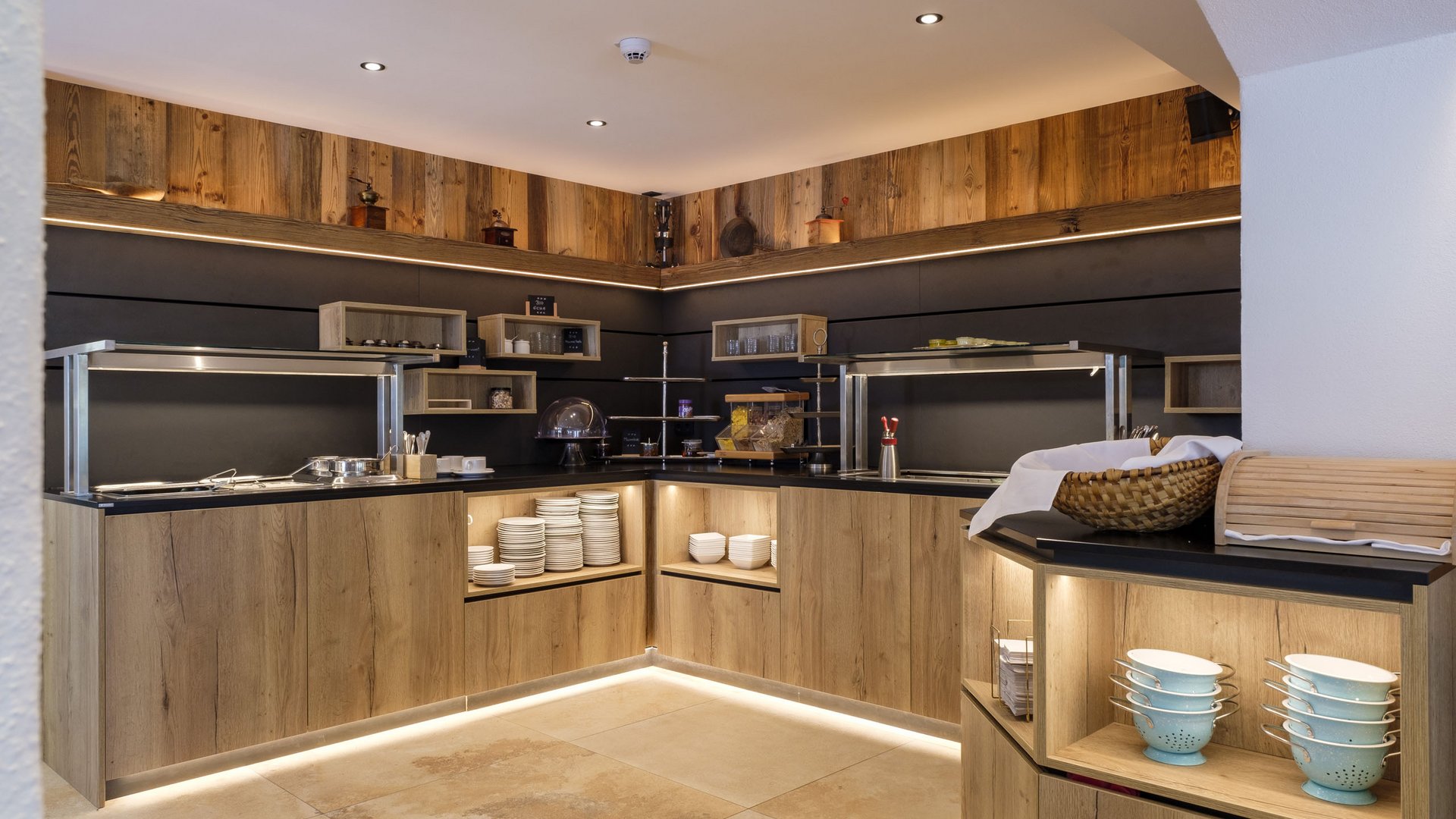 Modern buffet with wooden cabinets, LED lighting, and kitchen utensils