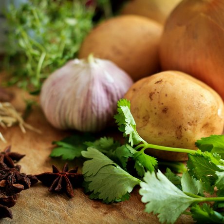 A look at Alte Wurzhütte Potatoes, onions, garlic, star anise and fresh herbs on cutting board