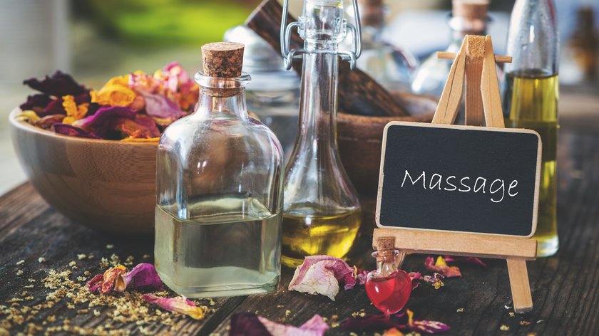 Massagen und Sauna am Spitzingsee Massageölflaschen mit getrockneten Blumen und kleinem Tafelaufschrift Massage