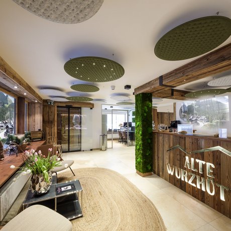 A look at Alte Wurzhütte Reception and lounge area of Alte Wurzhütte hotel with wooden accents and green decor