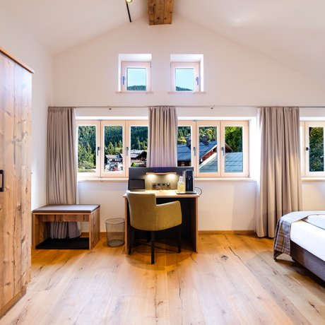 A look at Alte Wurzhütte Bright bedroom with large windows and wooden furniture